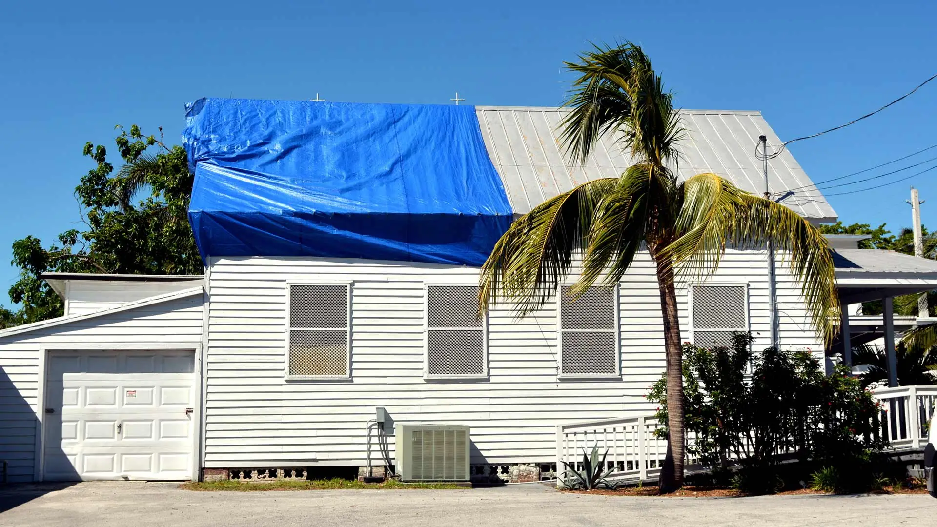 A home in Lakeland, FL with a tarp covering roof damage.