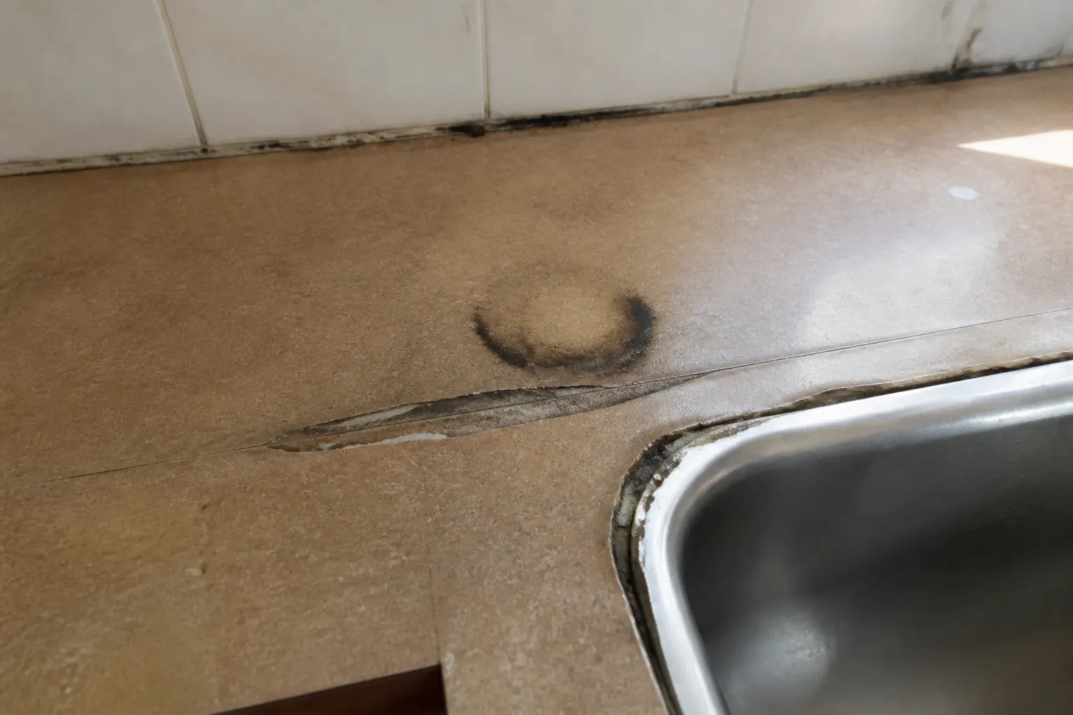 Chipped laminate kitchen countertop before quartz or granite installation in Lakeland FL